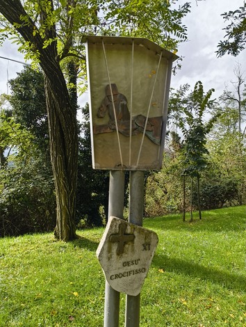 Scultura della Via Crucis di Casaglia, simbolo di meditazione e spiritualità immerso nel verde.