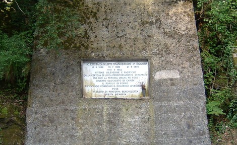 Lapide commemorativa dedicata ai frati della Certosa di Lucca, situata in un contesto naturale ricco di storia.
