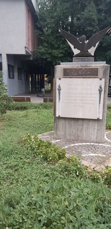 Monumento della Liberazione con un'aquila rappresentativa e basamento informativo in un giardino pubblico.