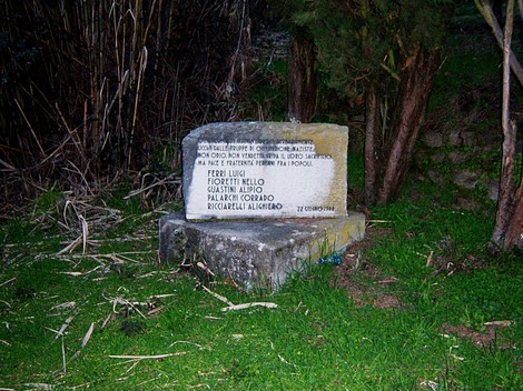 Cippo commemorativo dedicato a Ferri, Fioretti e altri, situato nella natura.