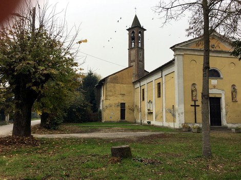 Lapide ai caduti di Cascinotto Mensa, con vista sulla chiesa e l'ambiente circostante.