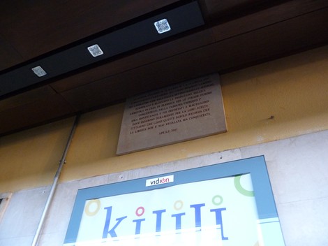 Lapide commemorativa dedicata ai lavoratori deportati, situata in un ambiente urbano.