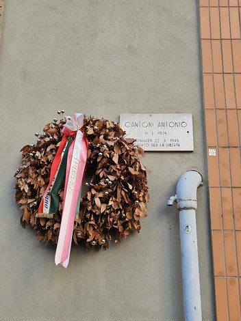 Lapide commemorativa con corona di foglie secche, dedicata a Cantoni Antonio per la libertà.