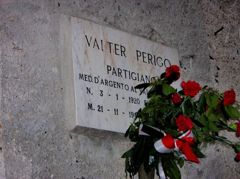 Lapide commemorativa di Valter Perigo, partigiano, con decorazioni floreali in memoria del suo sacrificio.