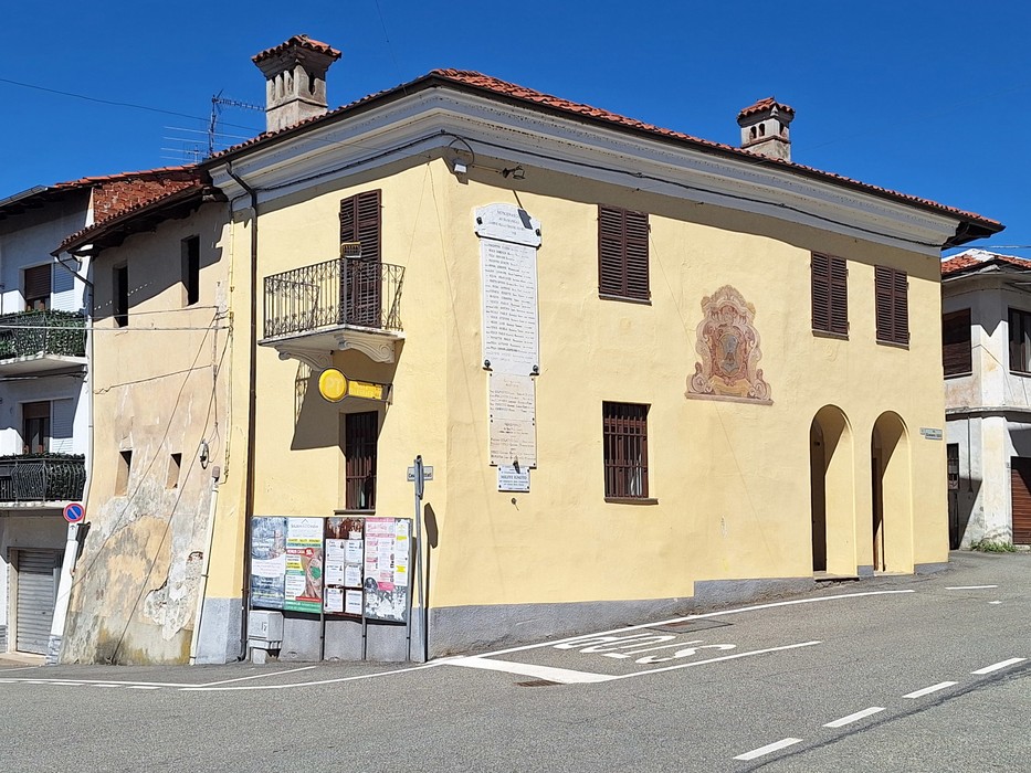 Lapidi commemorative ai caduti situate su un edificio giallo a Mercenasco, in un contesto urbano sereno.