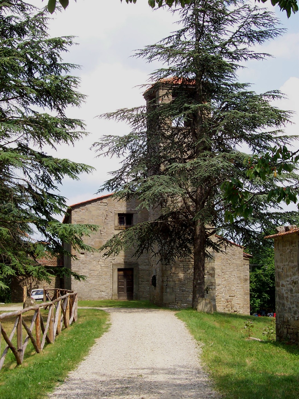 Lapide commemorativa dedicata ai civili e partigiani, situata in un contesto naturale e storico.