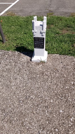 Cippi bianchi del viale della Rimembranza, con base in cemento e vegetazione circostante.