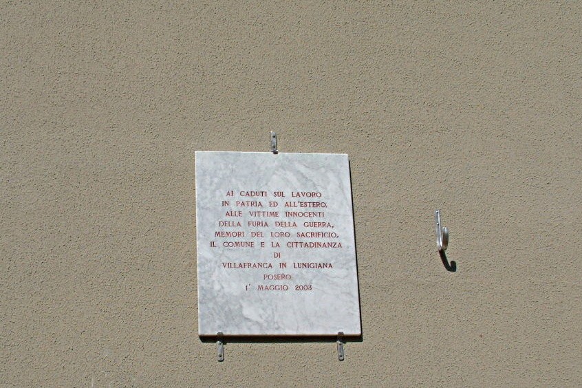 Lapide commemorativa dedicata ai caduti sul lavoro e in guerra, situata a Villafranca in Lunigiana.
