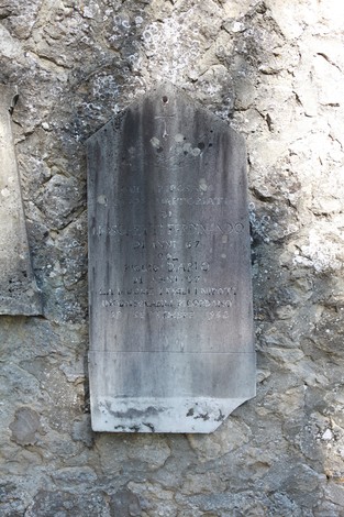 Vecchi sepolcri del cimitero di San Martino, con pietre tombali usurate dal tempo e dalla natura.