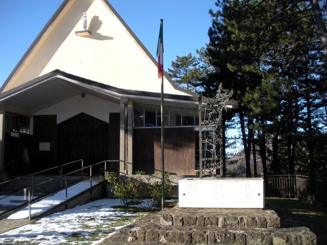 Monumento ai caduti di Brallo, commemorazione in un'area tranquilla con bandiera italiana e paesaggio naturalistico.