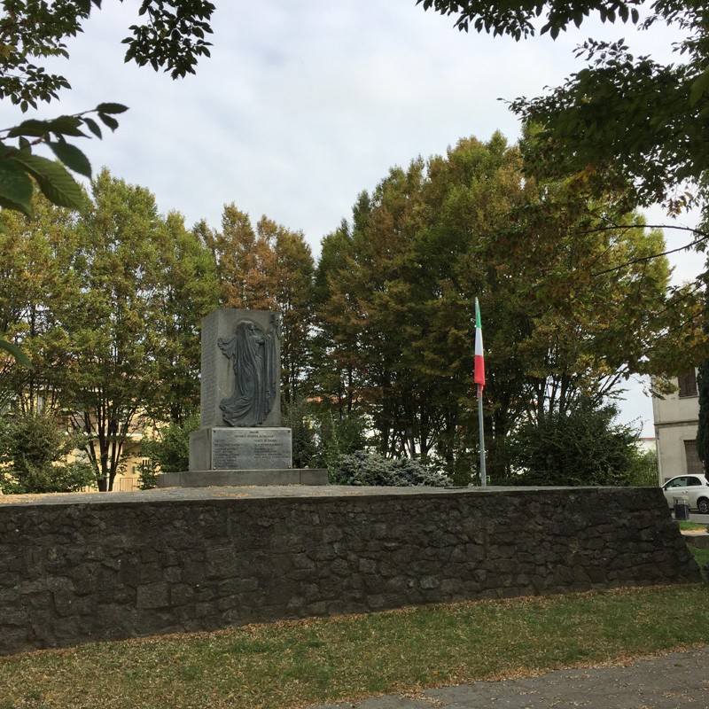 Monumento ai caduti di Sartirana Lomellina, dedicato alla memoria dei soldati. Verde e pietra lo circondano.