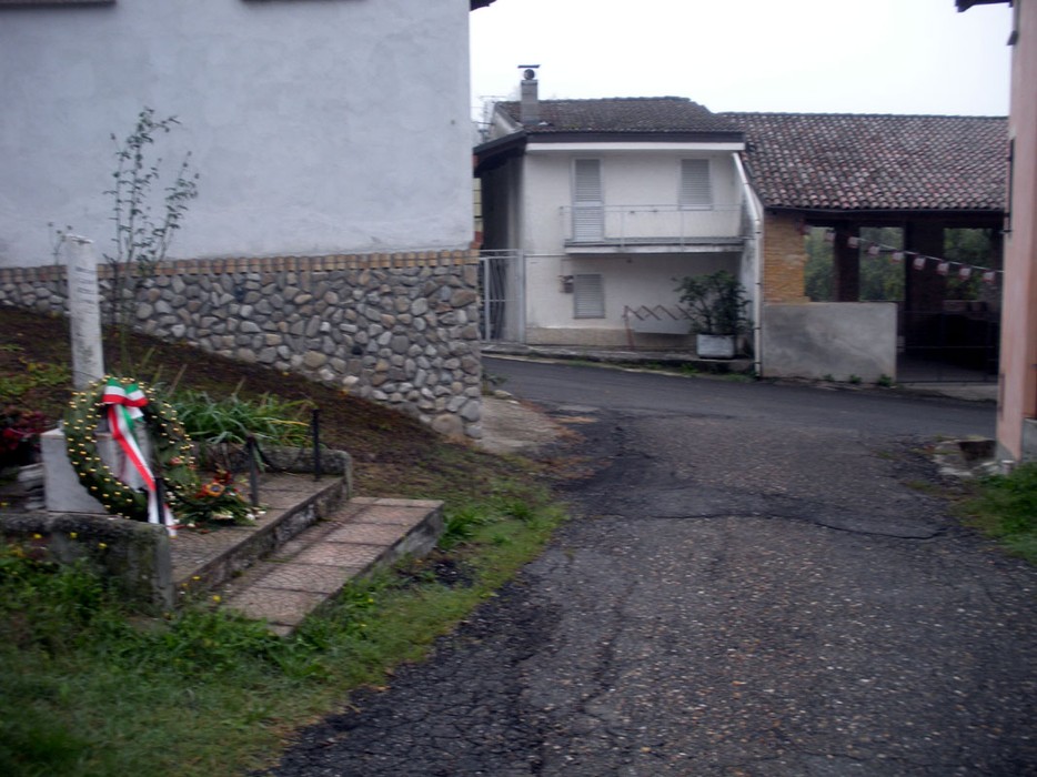 Cippo commemorativo a Brignoli, Clerici, Gemelli e Longa in un ambiente tranquillo e rurale.