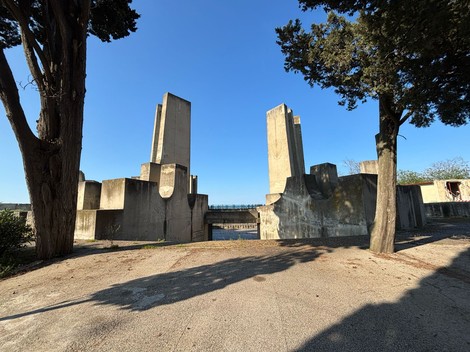 Ossario monumentale dedicato ai militari e partigiani jugoslavi, circondato da alberi e cielo sereno.