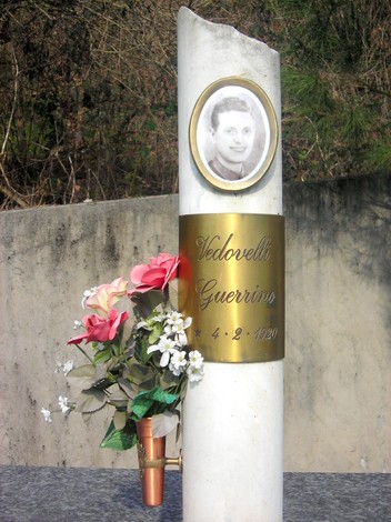 Monumento ai martiri della Garella, in memoria di Vedovelli Guerrino, con fiori e immagine commemorativa.