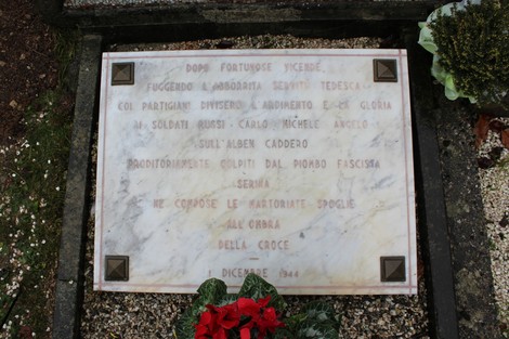 Monumento commemorativo ai caduti partigiani russi, con una stele e decorazioni floreali.