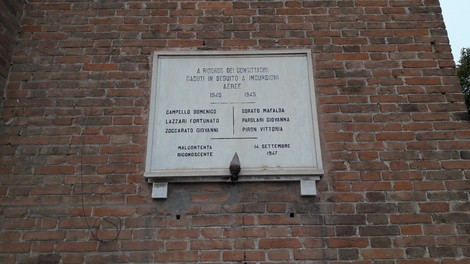 Lapide commemorativa in memoria delle vittime di bombardamenti, con nomi incisi in onore dei caduti.