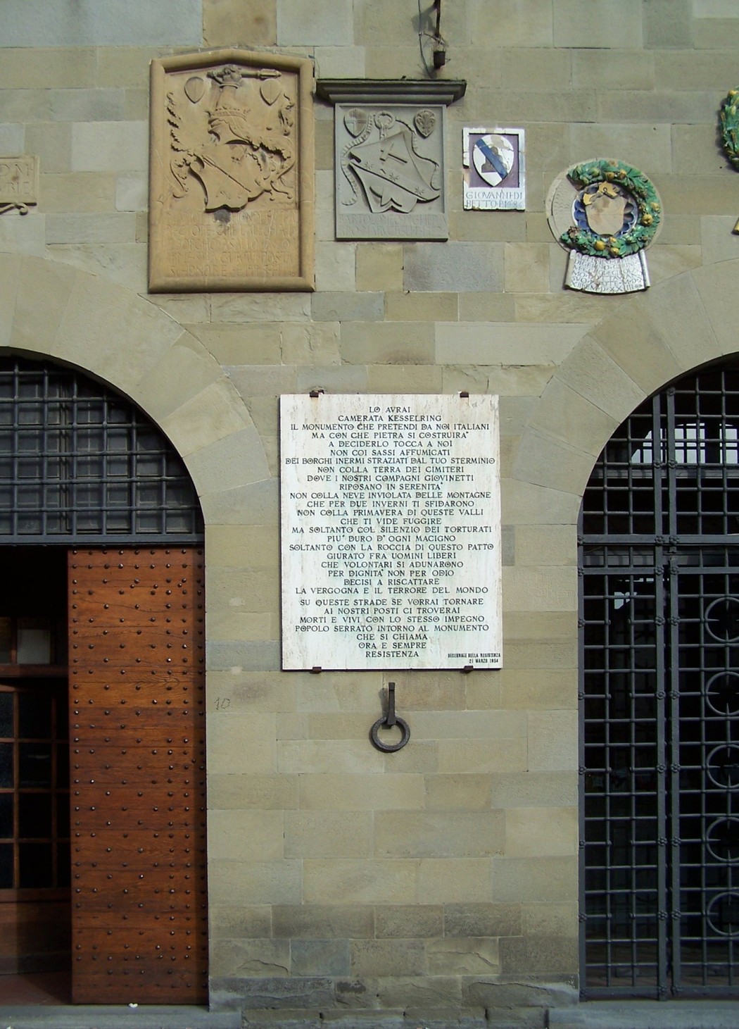Lapide commemorativa che celebra un decennio di eventi significativi, situata su una parete storica.
