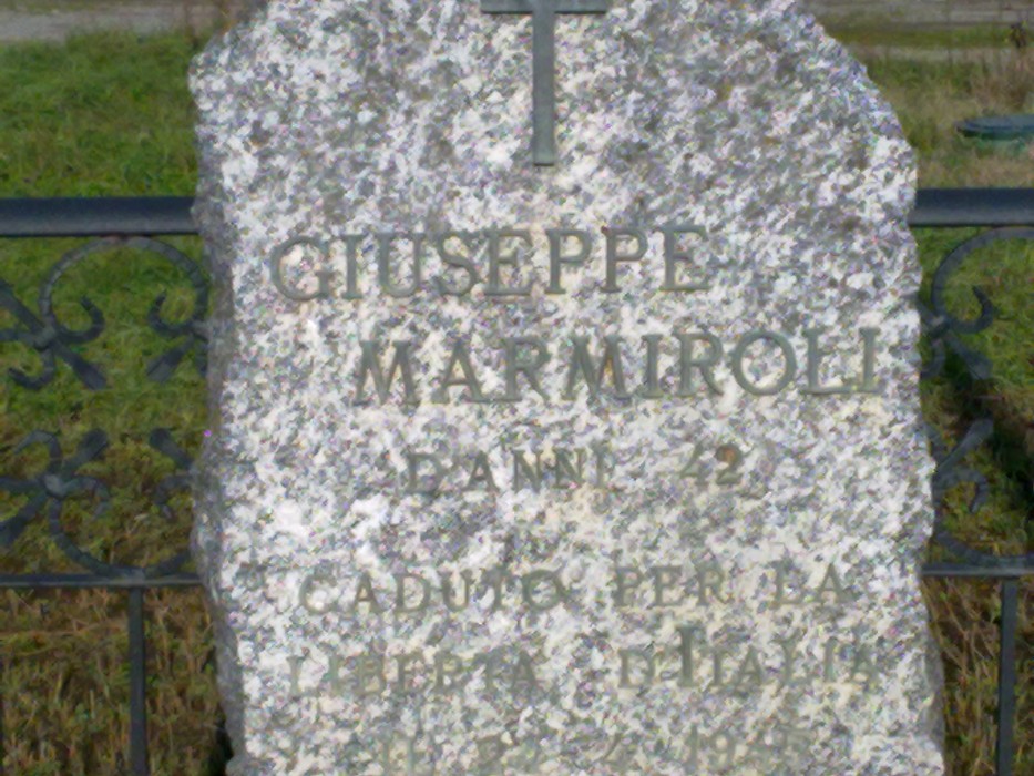 Cippo commemorativo in memoria di Giuseppe Marmiroli, situato in un contesto naturale.
