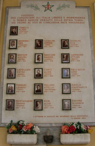 Lapide commemorativa ai Caduti della Resistenza di Poviglio, con nomi e omaggi floreali.