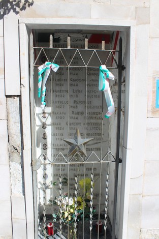 Cappella ai caduti di Molassana, commemorativa con decorazioni e fiori, simbolo di memoria e rispetto.