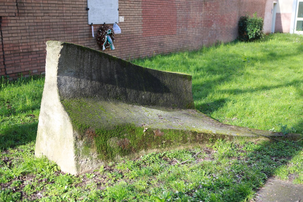 Struttura di pietra monumentale in un'area verde, simbolo della Resistenza, immersa nella natura.