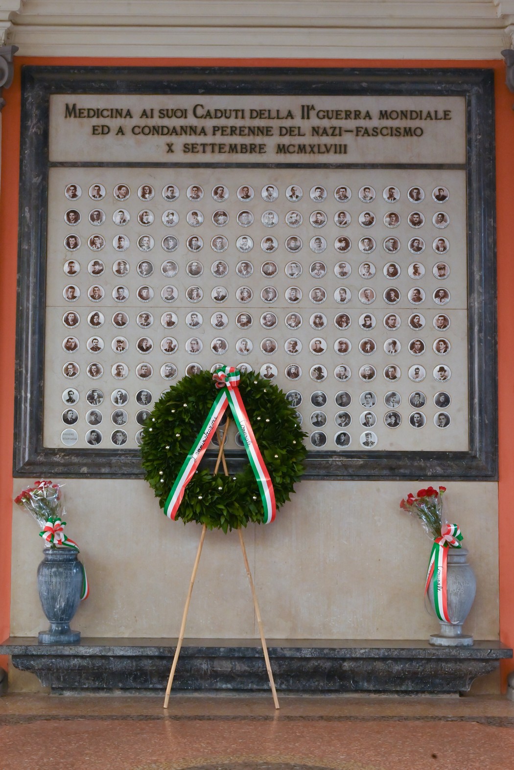 Sacrario dei caduti per la Libertà, con lapidi commemorative e una corona di fiori al centro.