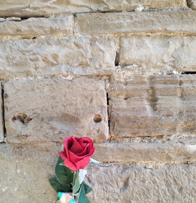 Lapide commemorativa con una rosa rossa, in onore dei civili e partigiani.