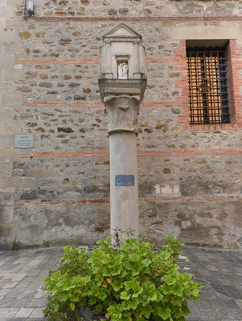 Colonna con statua dedicata a Santa Maria Visitante, incastonata in un contesto storico.