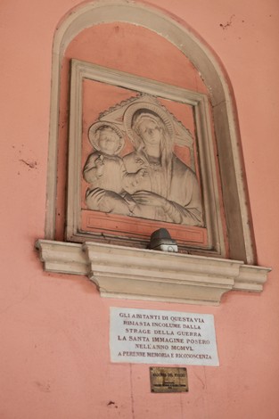 Ex-voto rivestito di significato religioso, commemorante i bombardamenti con immagini sacre e dedica alla memoria.