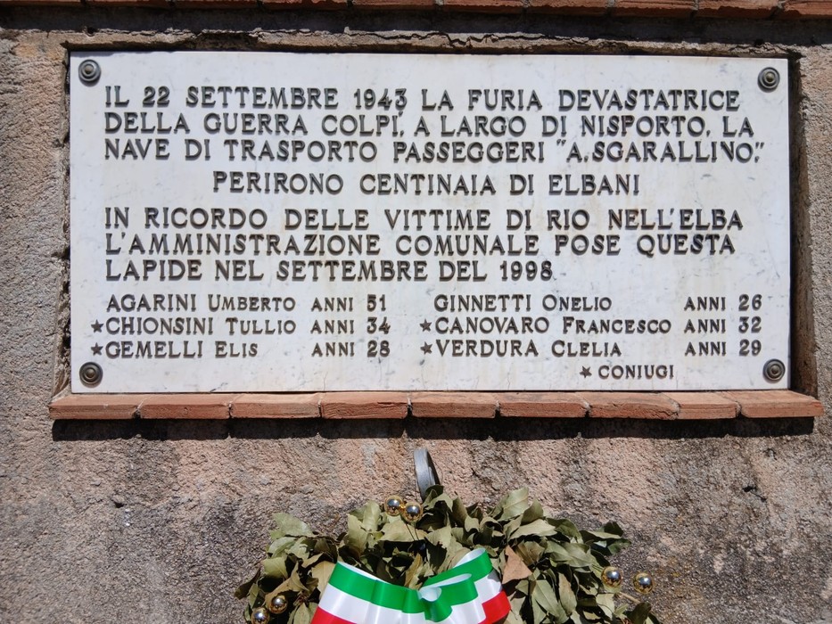 Lapidi commemorative dedicate ai caduti di Rio nell'Elba, con una corona di fiori.