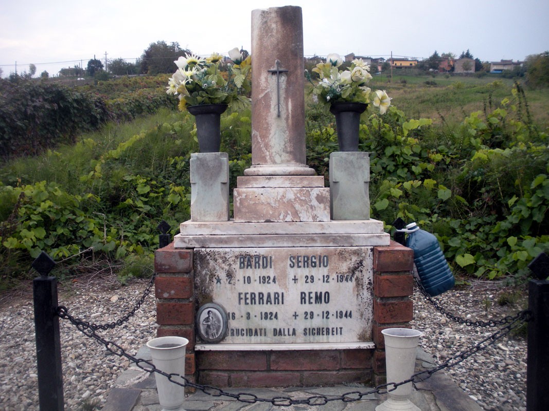 Cippo commemorativo in onore di Sergio Bardi e Remo Ferrari, situato in un'area rurale.