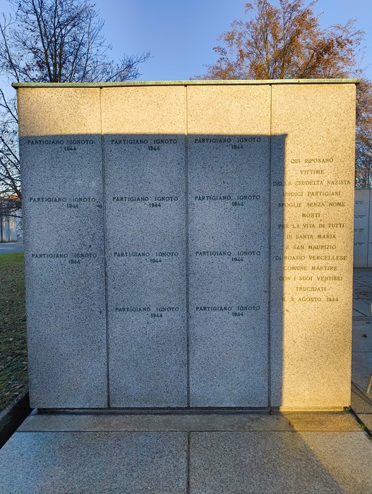 Monumento commemorativo con dedicazioni ai partigiani, Campo della Gloria, in un contesto sereno e riflessivo.