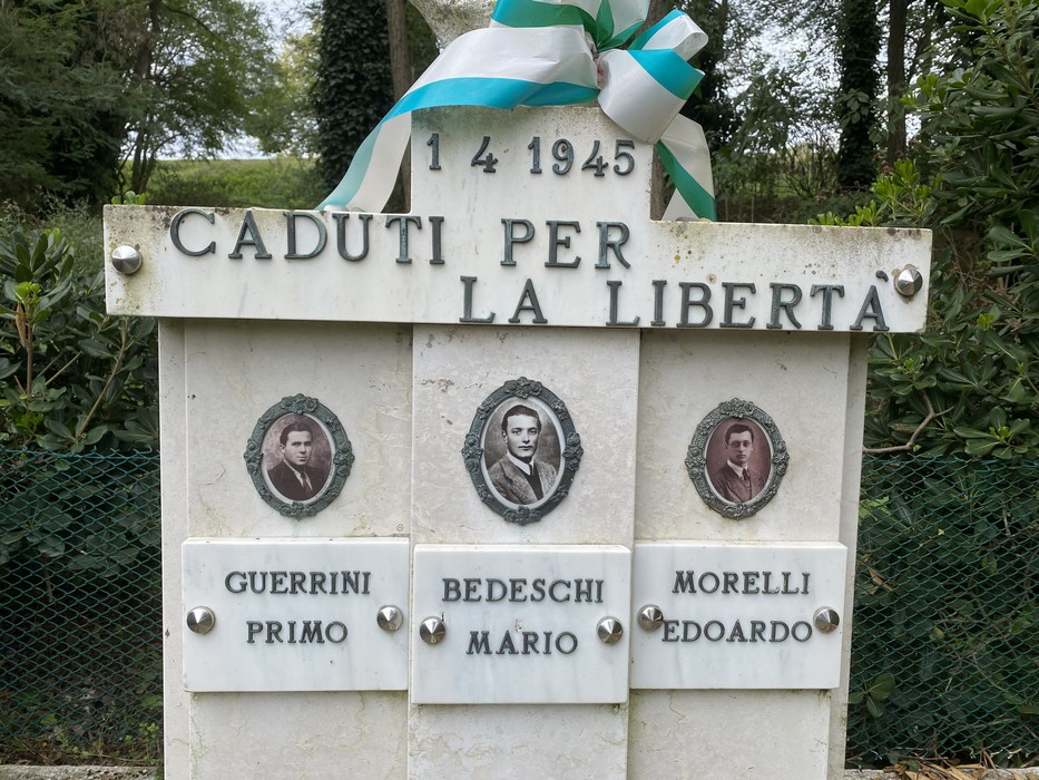 Monumento commemorativo con ritratti in campo bianco dedicato ai caduti per la libertà.