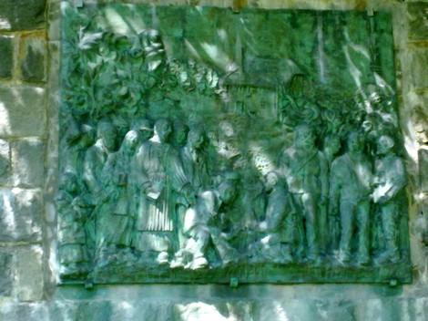Rappresentazione del "Monumento al Passo Pradarena" con figure storiche e commemorative in rilievo.