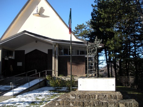 Monumento ai caduti di Brallo, commemorazione in un'area tranquilla con bandiera italiana e paesaggio naturalistico.