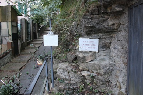 Lapide commemorativa della Brigata Guglielmetti, situata in un ambiente naturale e storico.