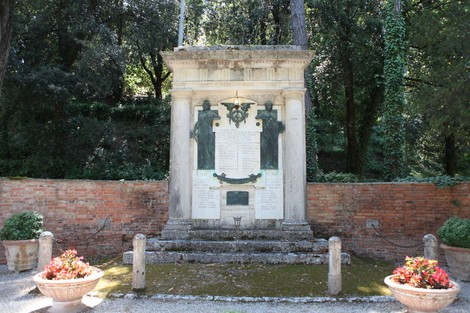 Monumento ai Caduti di Petroio, con iscrizioni commemorative e decorazioni floreali circostanti.