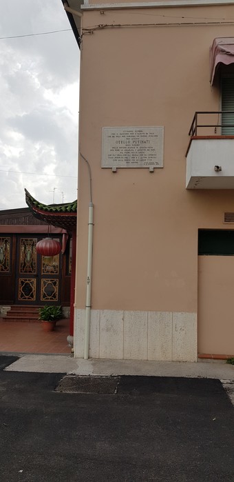 Lapide commemorativa su un edificio, con un testo di significato storico.