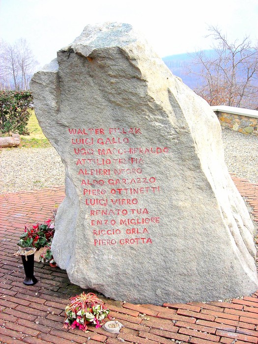 Monumento che onora i comandi della 7° e 76° Divisione Garibaldi, con nomi incisi su una grande roccia.
