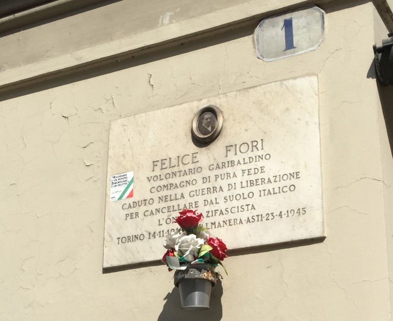 Lapide commemorativa di Felice Fiori, volontario garibaldino, con fiori. homenaggio alla sua memoria.