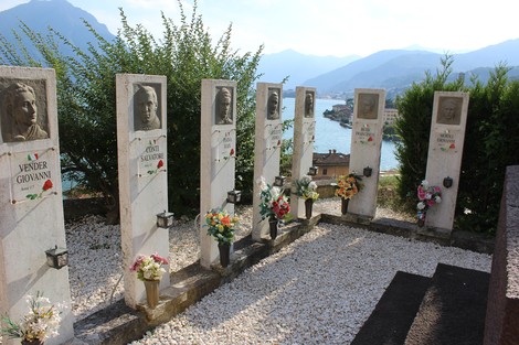 Sacrario dei Tredici Martiri con lapidi decorate e vista panoramica sul lago e montagne circostanti.