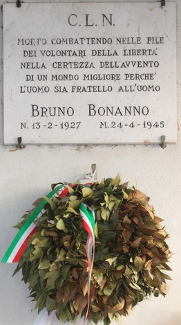 Lapide commemorativa dedicata a Bruno Bonanno, decorata con una corona di alloro e nastri tricolori.