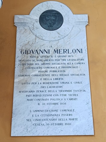 Lapide commemorativa dedicata a Giovanni Merloni, con dettagli sulla sua vita e impegno politico.