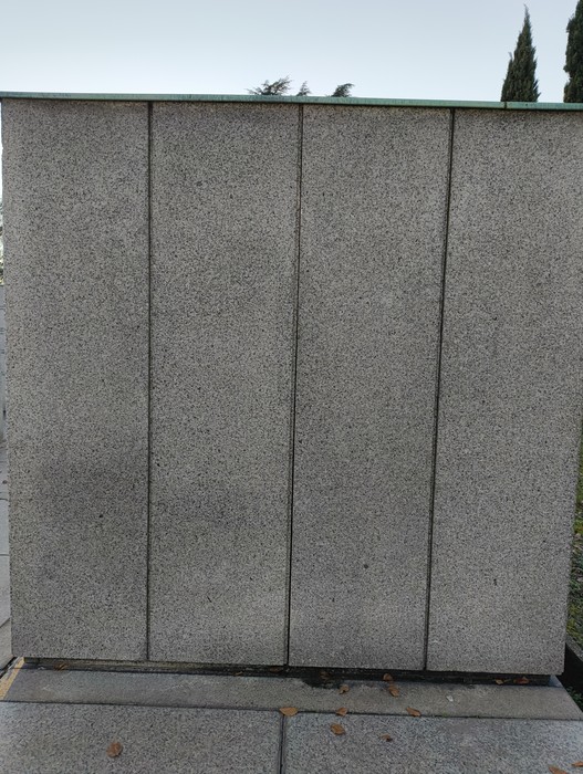 Campo della Gloria, monumento commemorativo con pareti in pietra, immerso in un'atmosfera di rispetto e ricordo.