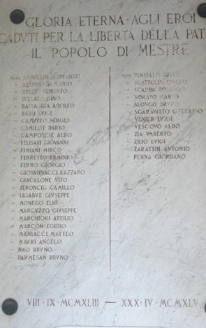 Lapide commemorativa dedicata ai partigiani mestrini caduti per la libertà. È incisa su marmo bianco.