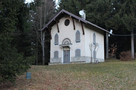 Cippo a Valdo, edificio in stile alpino circondato da boschi e vegetazione, con dettagli architettonici caratteristici.