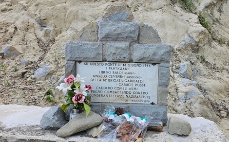 Monumento dedicato a Baldi e Cevenini, con fiori e una lapide in ricordo dei partigiani caduti.