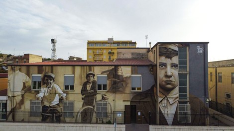 Murale commemorativo su un edificio, raffigurante figure storiche e culturali di Butera.