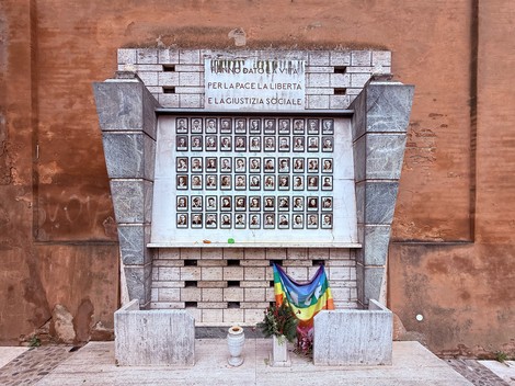 Sacrario dei caduti partigiani, monumento commemorativo con foto e fiori, simboleggia pace e libertà.
