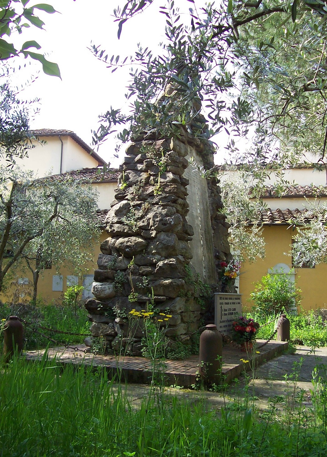 Monumento ai caduti di Varlungo, immerso nel verde, commemorativo e caratterizzato da elementi rustici.